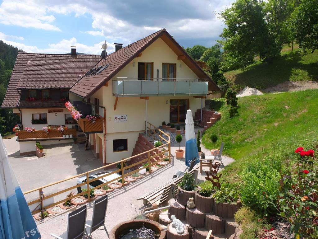 a house with a balcony and a patio with a surfboard at Paradies Im Schwarzwald in Bad Peterstal-Griesbach