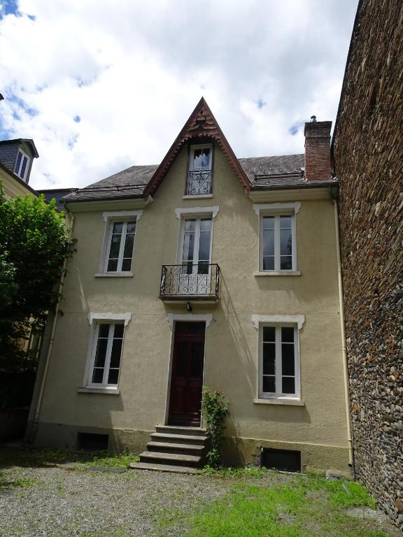 a yellow house with a balcony and a door at Le Clos du Casino in Luchon