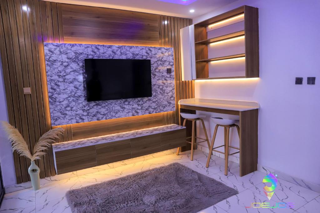 a room with a tv and a bar with a stool at Winners Aparments in Mama