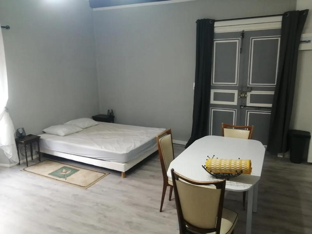 a bedroom with a bed and a table and chairs at Gradina Bulgarana in Bourg-Argental