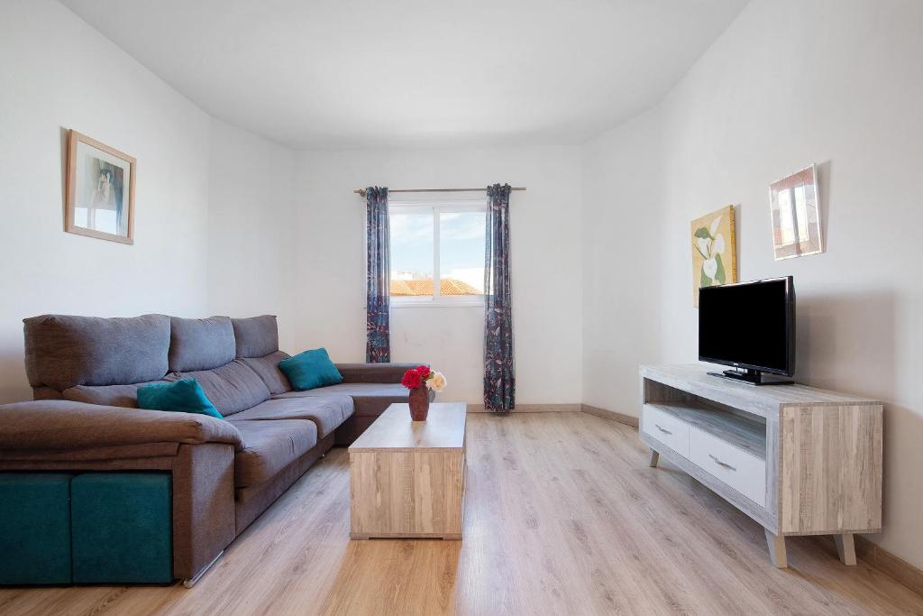 a living room with a couch and a tv at Casa Tanai in El Cotillo