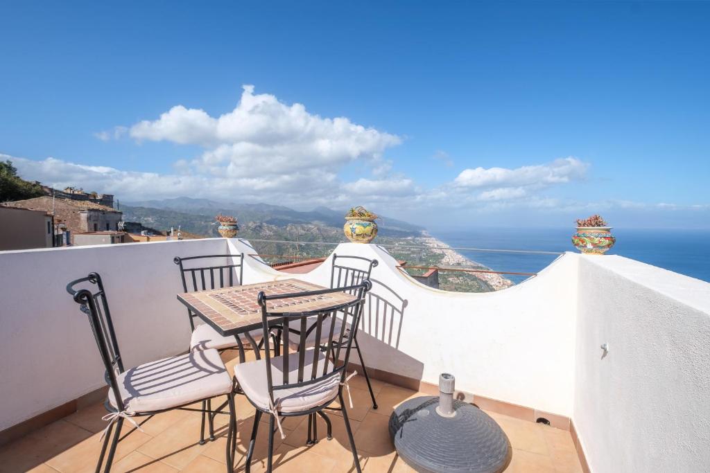 a balcony with a table and chairs and the ocean at Casa Mark in Forza dʼAgro