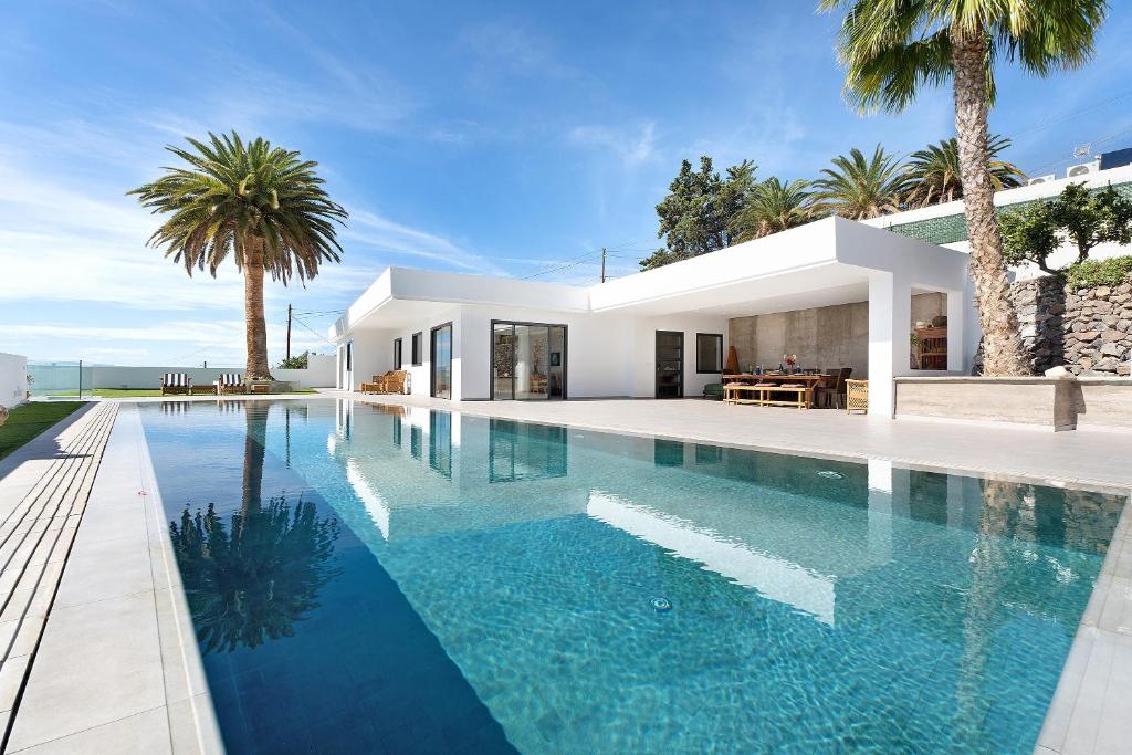 a swimming pool in front of a house at Alba House in Adeje