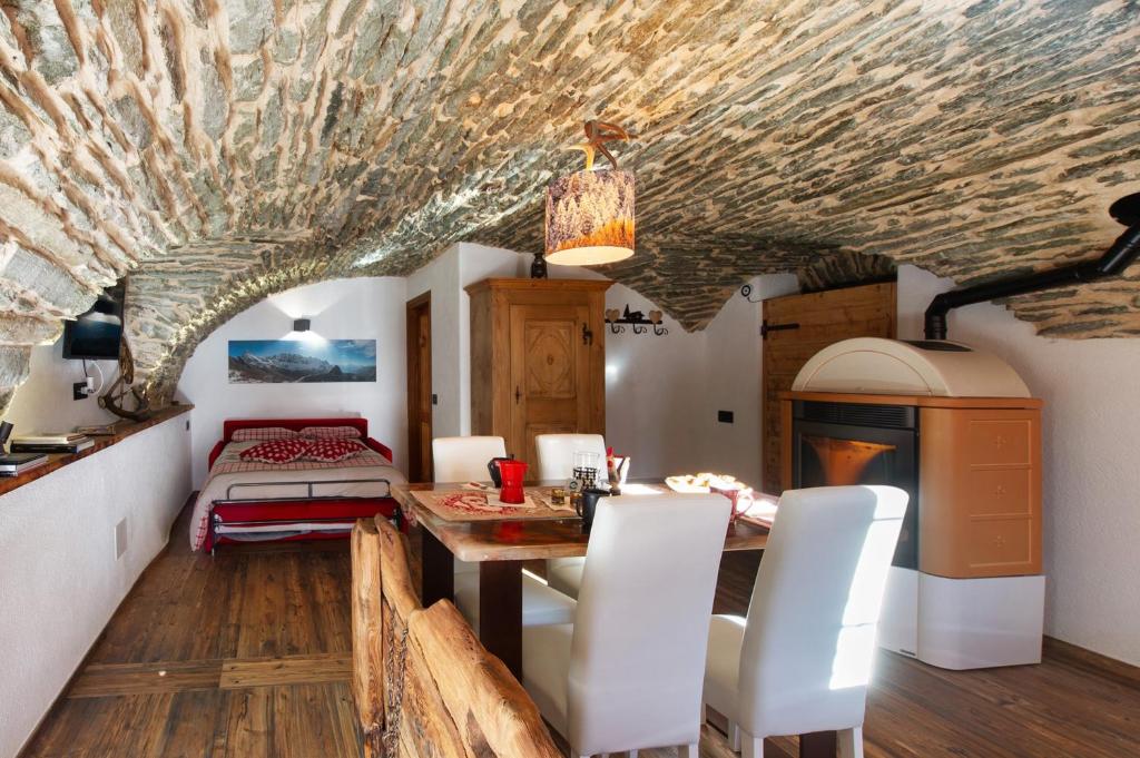 eine Küche und ein Esszimmer mit Tisch und Stühlen in der Unterkunft La Cachette Relax in Aosta