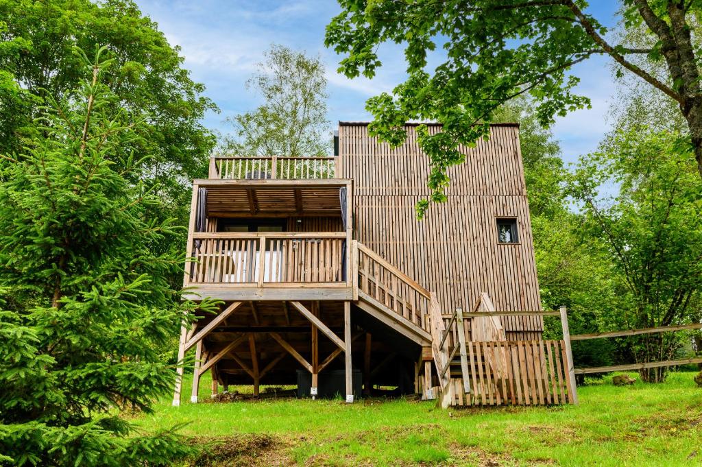 a tree house with a deck and a fence at Gîte Le Pieraline - Ventron in Ventron