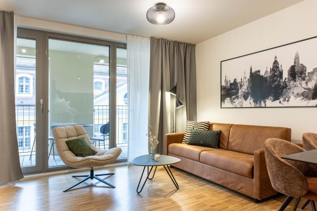 a living room with a couch and a table at AlegraStay Apartments - Dresden City in Dresden