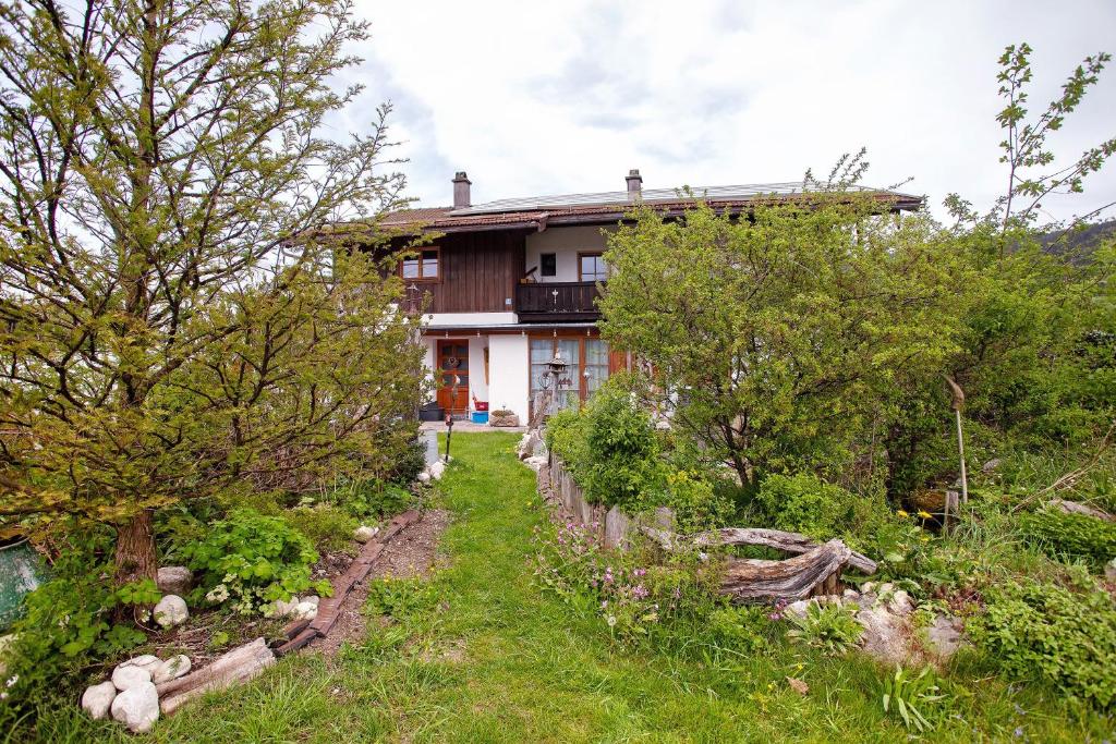 a house in the middle of a field with trees at Ferienwohnung beim Roana in Inzell