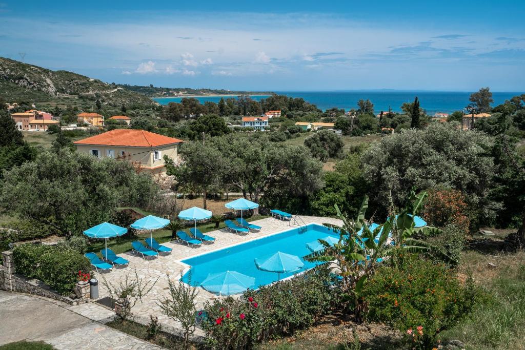 an image of a swimming pool with umbrellas and the ocean at Anemona studio B in Kefallonia