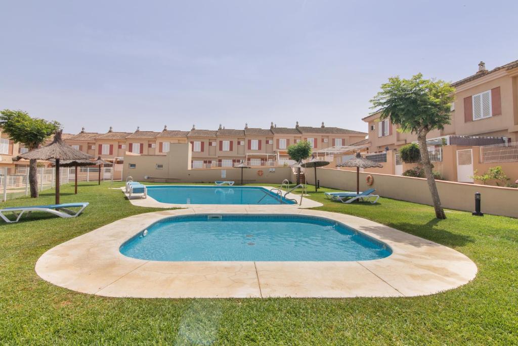 a swimming pool in a yard with buildings in the background at Puerta Marina Costa de la Luz in La Redondela