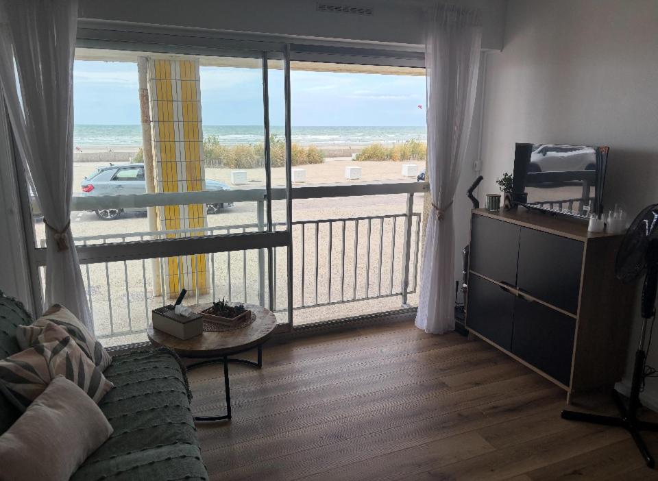 a living room with a large window with a view of the beach at Suite GrandLarge in Berck-sur-Mer