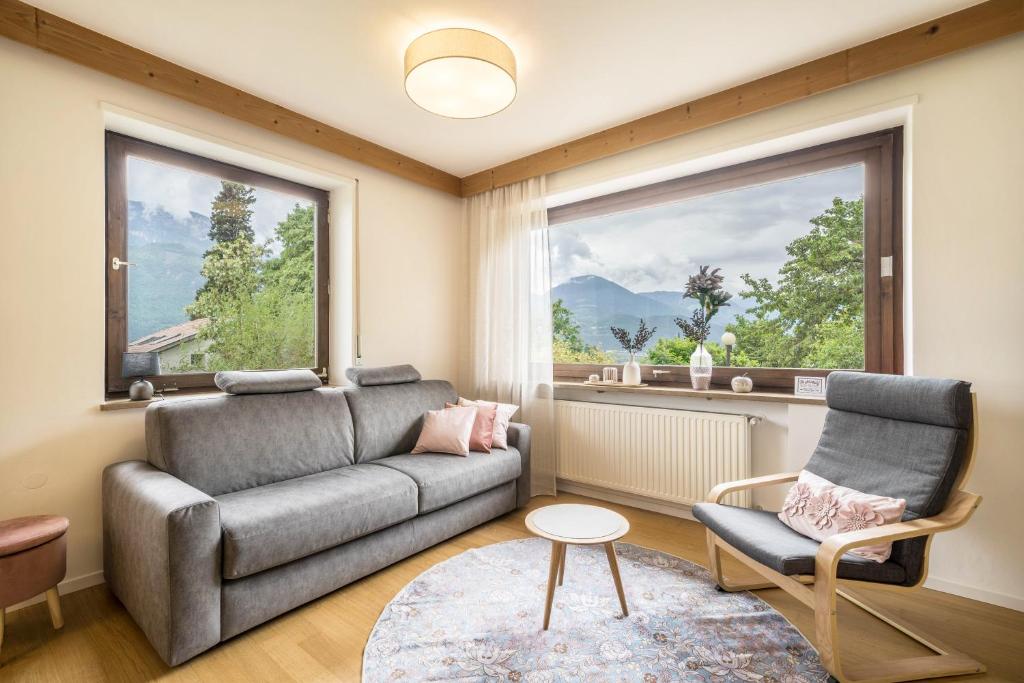un soggiorno con un divano, una poltrona e una finestra di Villa Pinie Apt 2 a Terlano