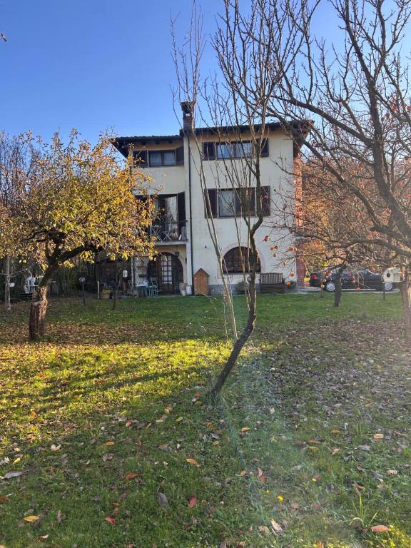 a tree in a field in front of a building at Campagna tutta da vivere in Arquata Scrivia