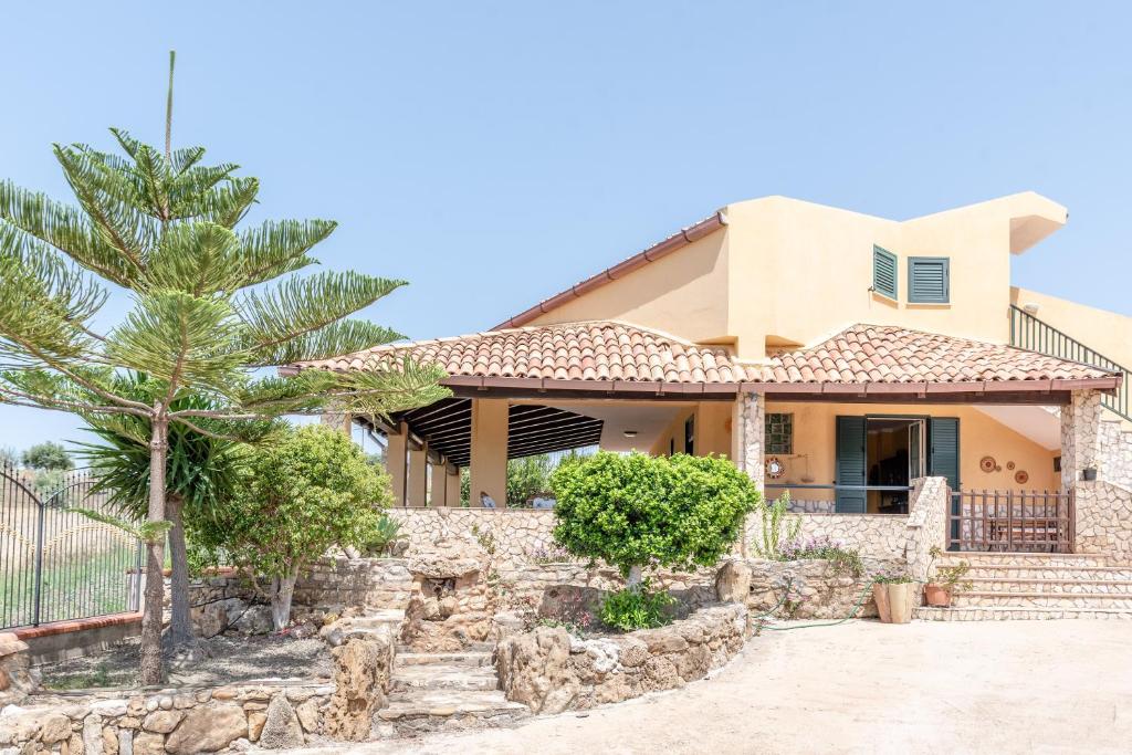 a house with a palm tree in front of it at Villa Tre 's' in Montallegro