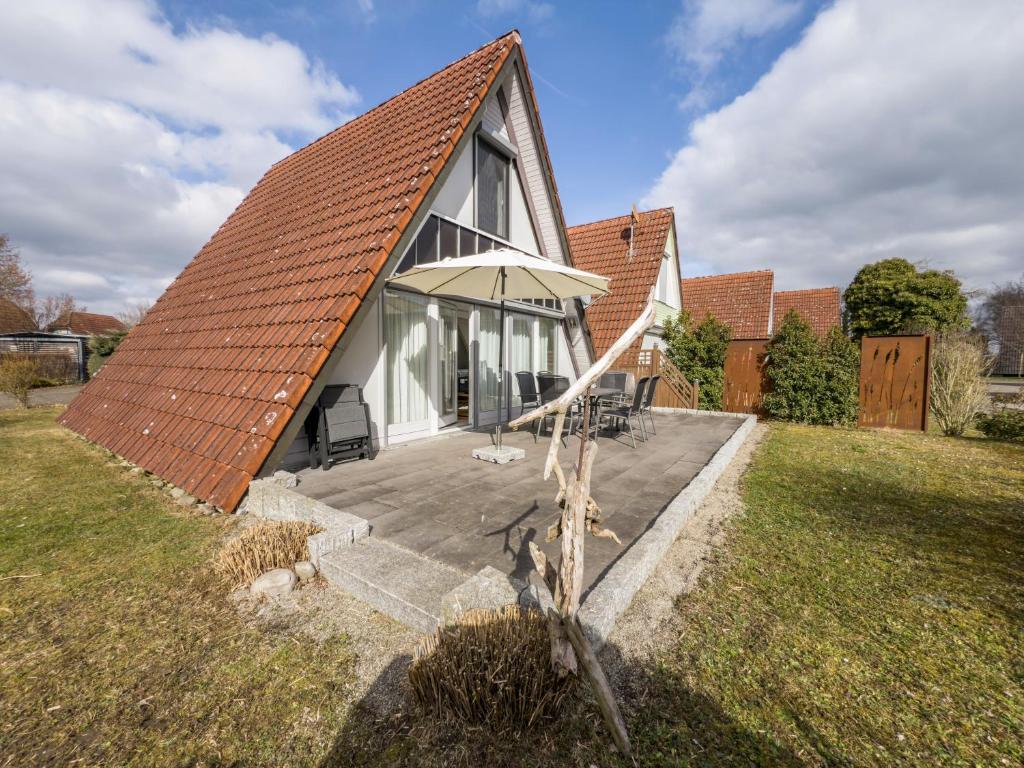 a small house with an orange roof with a patio at Wikinger 74 in Immenstaad am Bodensee