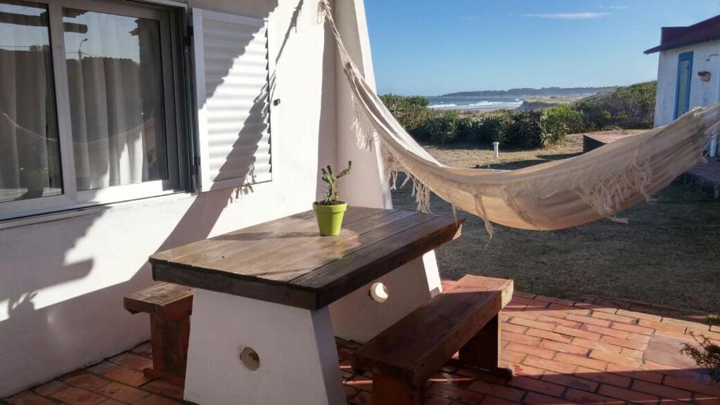 a hammock and a bench in front of a house at Conaguademar in La Paloma