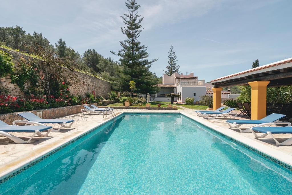 a swimming pool with lounge chairs and a house at Can Joan Vich I in Santa Eularia des Riu