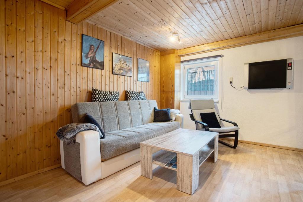 a living room with a couch and a table at Ferienhaus Am Darß - Leuchtturm in Pruchten