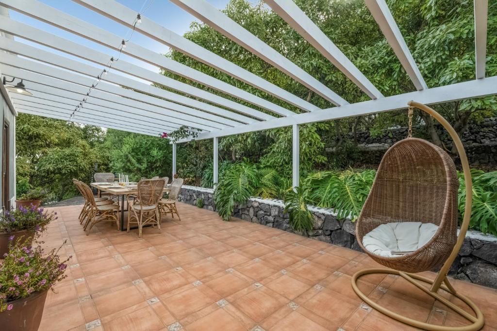 a patio with a table and chairs under a pergola at Caldera de Taburiente Rural in El Paso