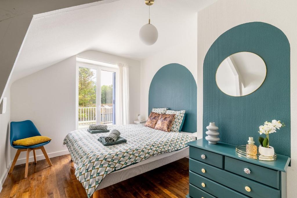a bedroom with a bed with a blue dresser and a mirror at La maison des chevaux in Saint-Vran