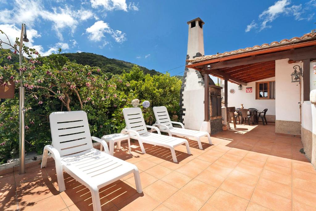 a group of white chairs sitting on a patio at Casa Rural Medina 1 in Agulo