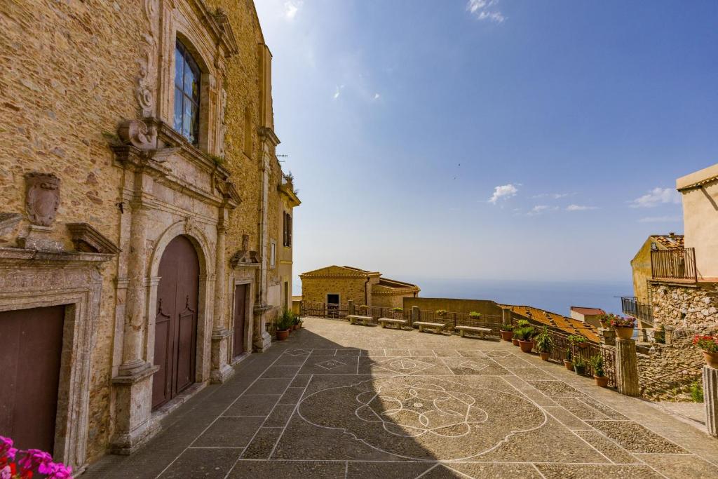 an alley in an old building with the ocean in the background at Ospitalità D'alunzio in San Marco dʼAlunzio