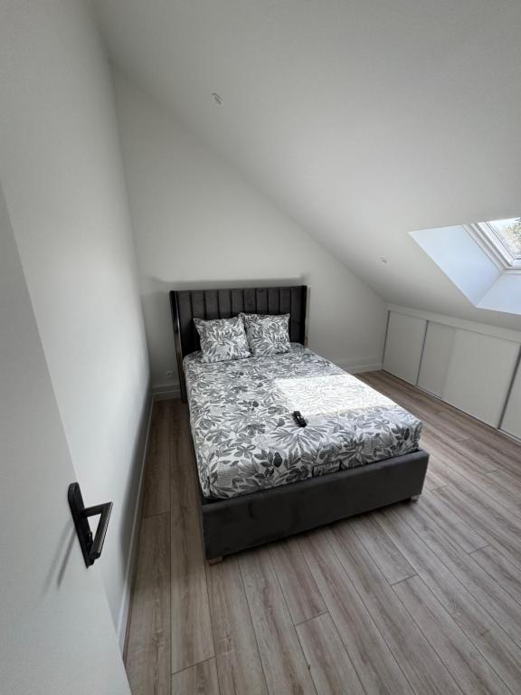 a bedroom with a bed and a skylight at Appartement 3 morangis in Morangis