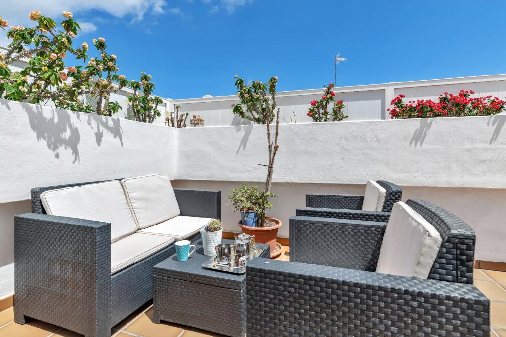 two wicker chairs and a table on a patio at Coqueto y tranquilo Apartamento in Puerto del Carmen