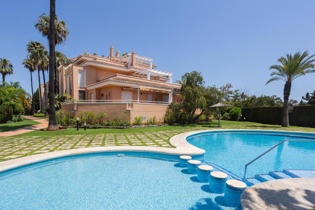 a villa with a swimming pool in front of a house at Keops in Oliva