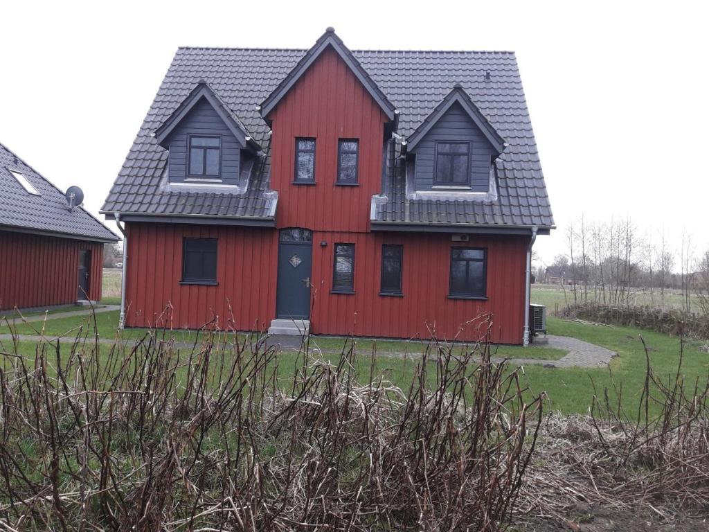 a red house with a black roof at Dat rode Huus in Oesterwurth