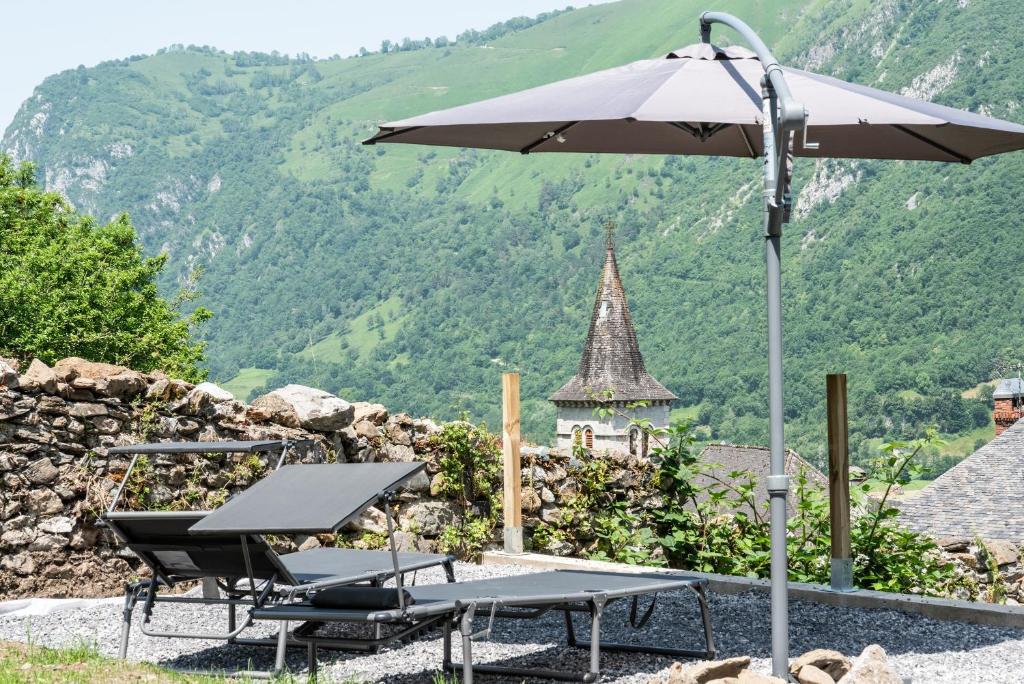 an umbrella and a table and chairs with a view at Au Milan D'ore - Pyrénées in Gère-Belesten