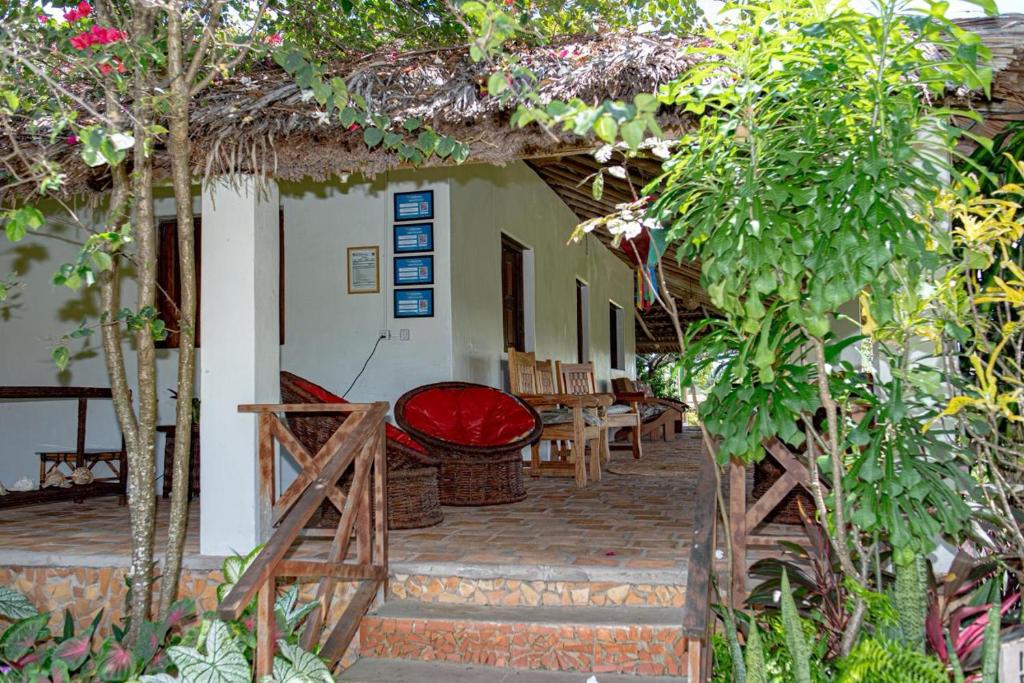a porch of a house with a red seat at POUSADA e HOSTEL SÍTIO PARAÍSO DO CAJU in Barreirinhas