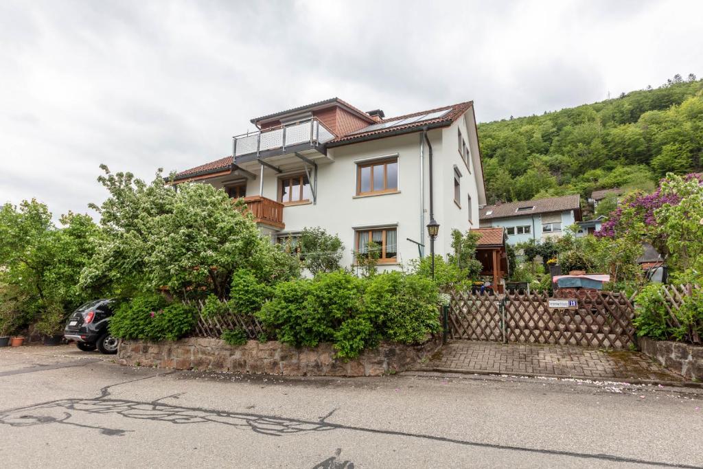 a white house with a hill in the background at Haus Michler in Todtnau