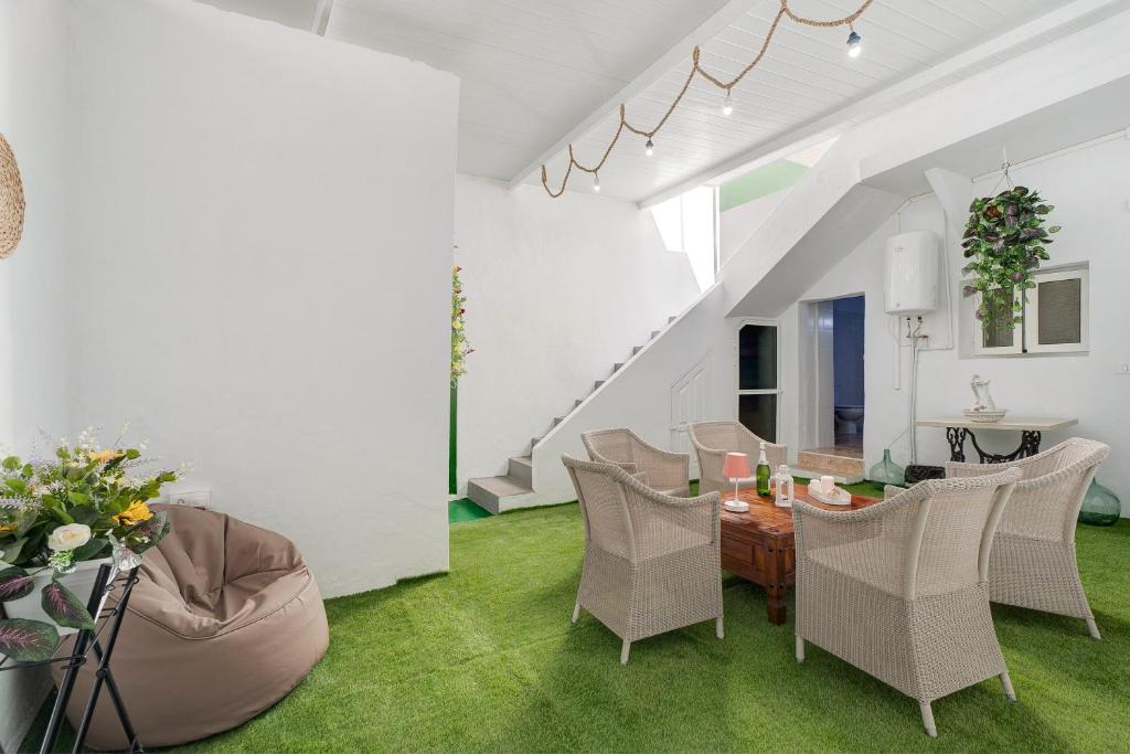 a living room with white walls and green grass at La Casa de Tina in Playa de San Juan