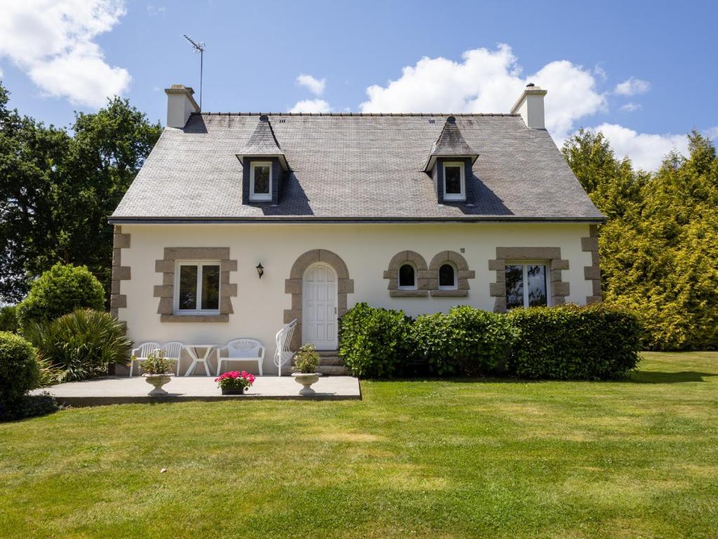 a house with a green lawn in front of it at Maison familiale terrasse et parc in Plouisy