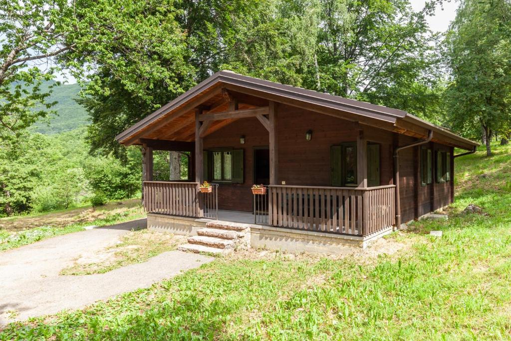 a small cabin in the middle of a field at Villaggio Anemone - Chalet Castagno in Capanne di Sillano