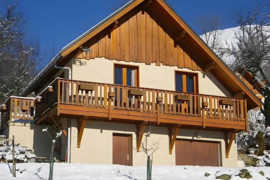 a house with a wooden deck in the snow at La Gelinotte - Jarrier in Jarrier