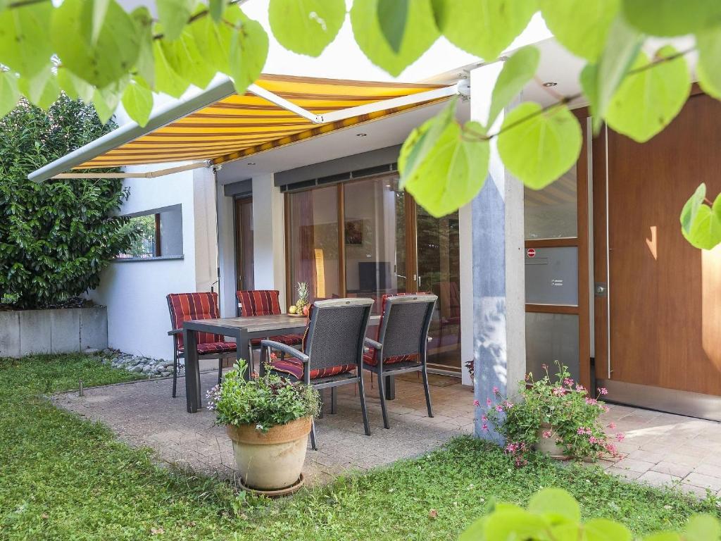 a patio with a table and chairs under an umbrella at Ferienwohnung Kobl in Immenstaad am Bodensee