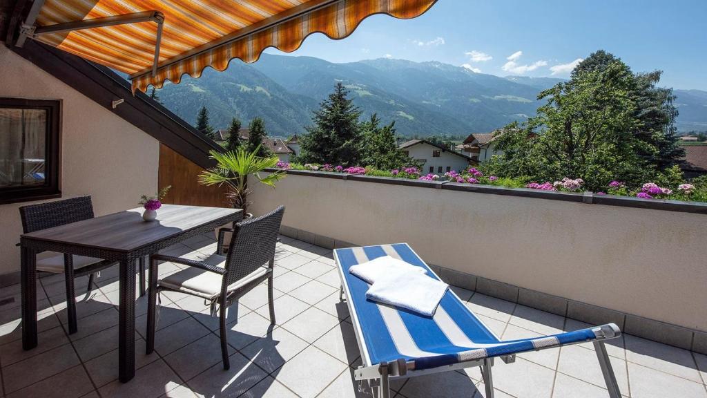 a patio with a table and chairs on a balcony at Schnitzer Ferienwohnung Anemone in Rablà