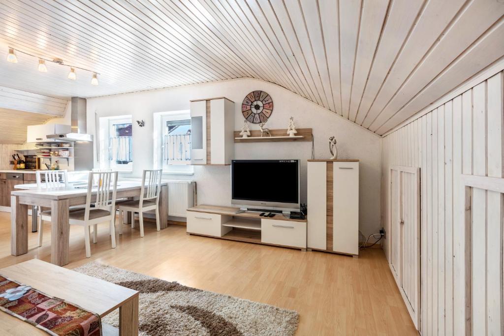 a living room with a television and a dining room at Ferienwohnung Fly in Wehr