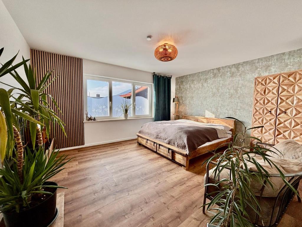 a bedroom with a bed and some potted plants at Fewo Dandelion in Haag
