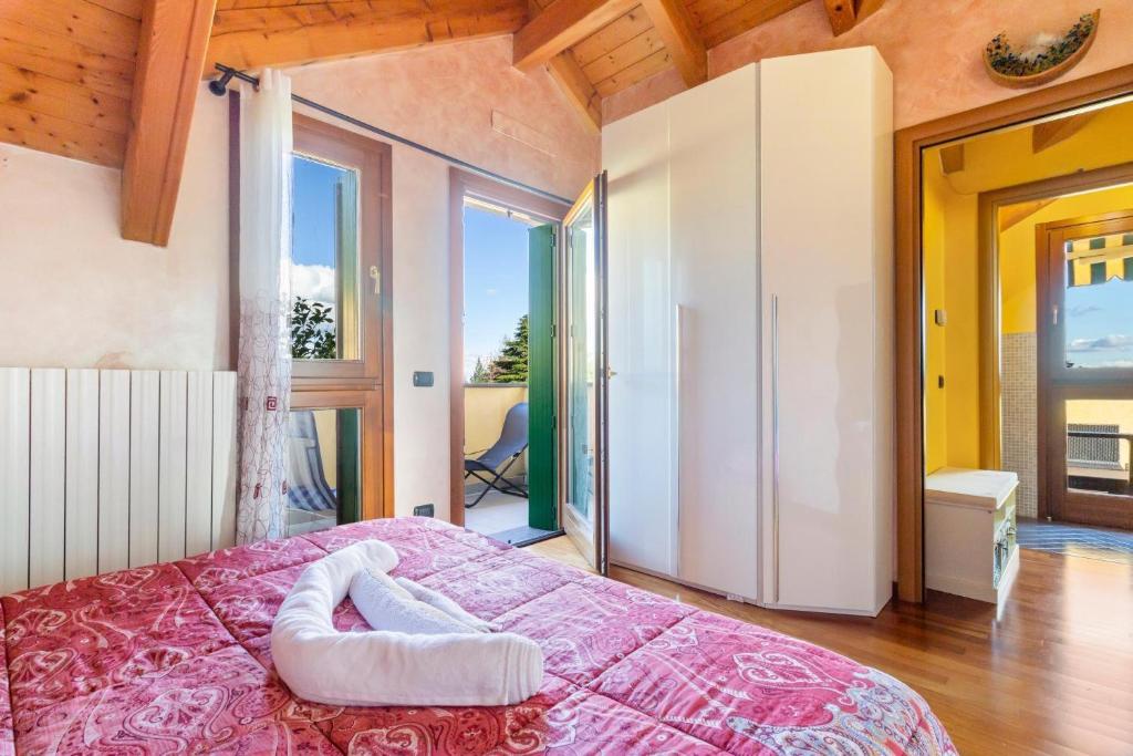 a bedroom with a bed with a pink bedspread at Lovely Orange House in Viggiù