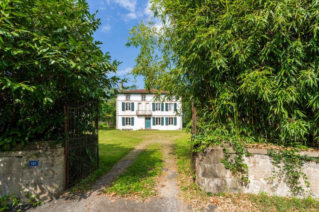 an entrance to a white house with trees at Maison Etxeparea in Ustaritz