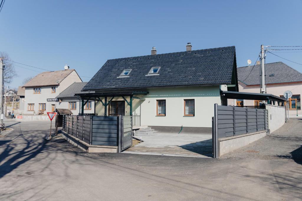 a white house with a black roof and a gate at Villa Jizbička in Náchod