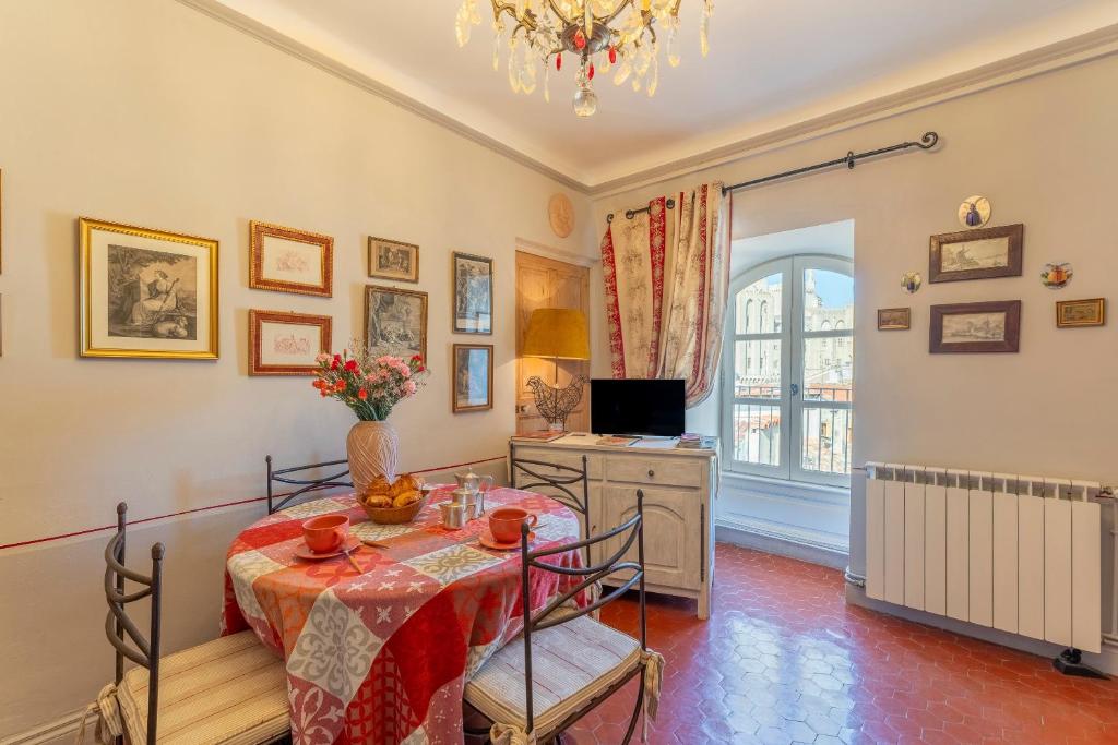 a dining room with a table and a television at Appart face au Palais des Papes in Avignon