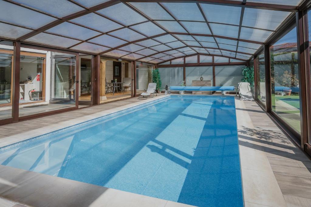 an indoor swimming pool with a large glass ceiling at La Costana De Barbadillo in Barbadillo del Mercado
