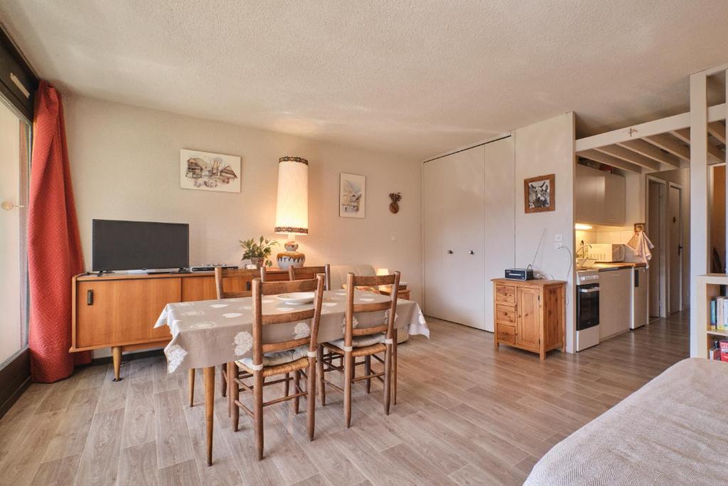 a living room with a dining table and a kitchen at Cosy and nice view on mountains in Villard-de-Lans