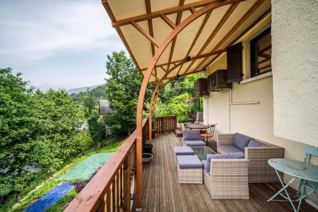 a deck with chairs and tables on a building at Chalet la Bartavelle - Morillon in Morillon
