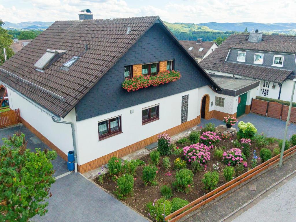 a model of a house with flowers in the yard at 65 qm Ferienwohnung im Sauerland in Finnentrop