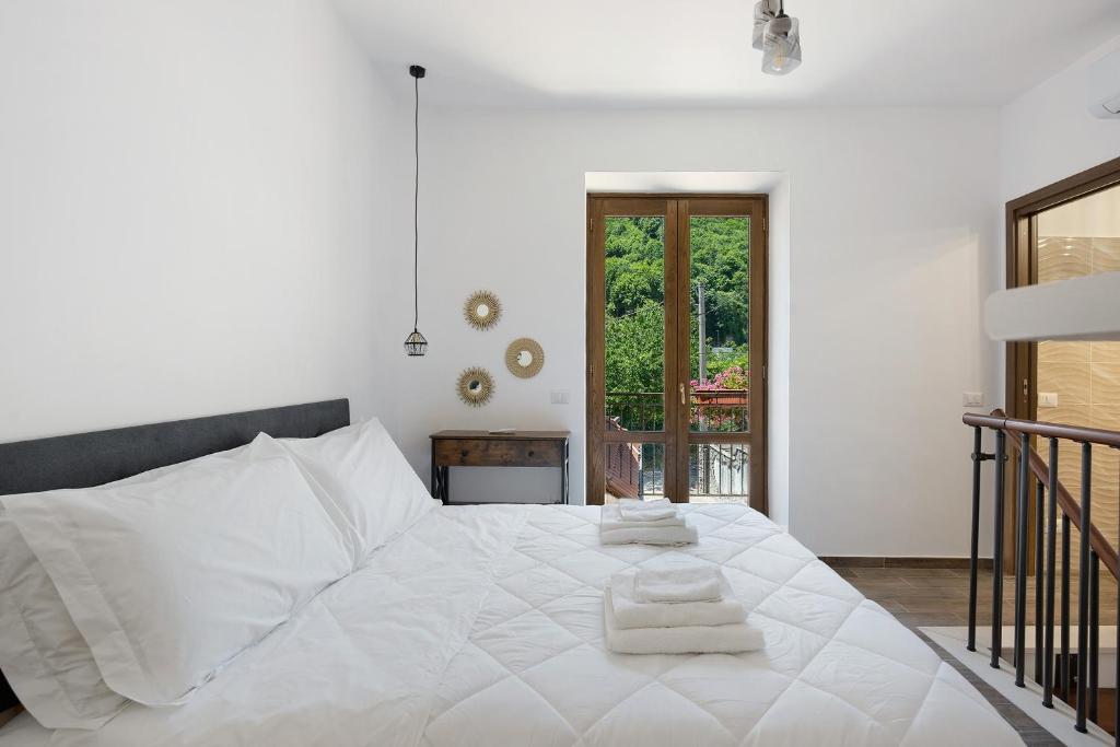 a bedroom with a white bed with towels on it at La Casetta In Canada' in Agerola