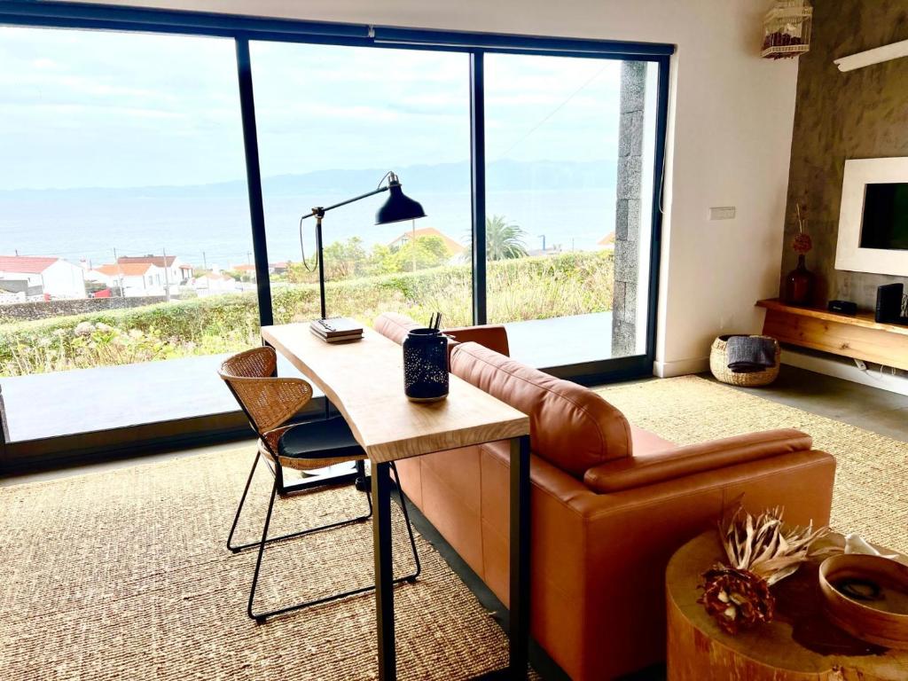 a living room with a desk and a chair and a couch at Casa da Arquinha in Santo Amaro